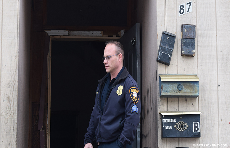 A police officer standing at the entrance of 87 Auburn Street as the house is being boarded up on Feb. 14th, 2017.