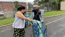 Firefighter Brandy Acosta handing out water to Paterson resident Yosemis Baldayac De Lopez at Eastside High School on Thursday.