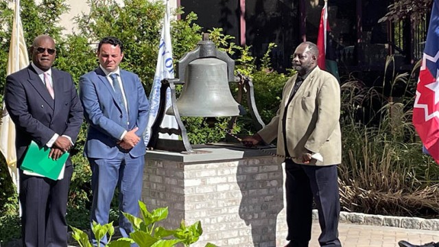 Historian Jimmy Richardson rings the Freedom Bell on Tuesday. Mayor Andre Sayegh and Dwayne Cox, president of the Paterson Parking Authority, look on.